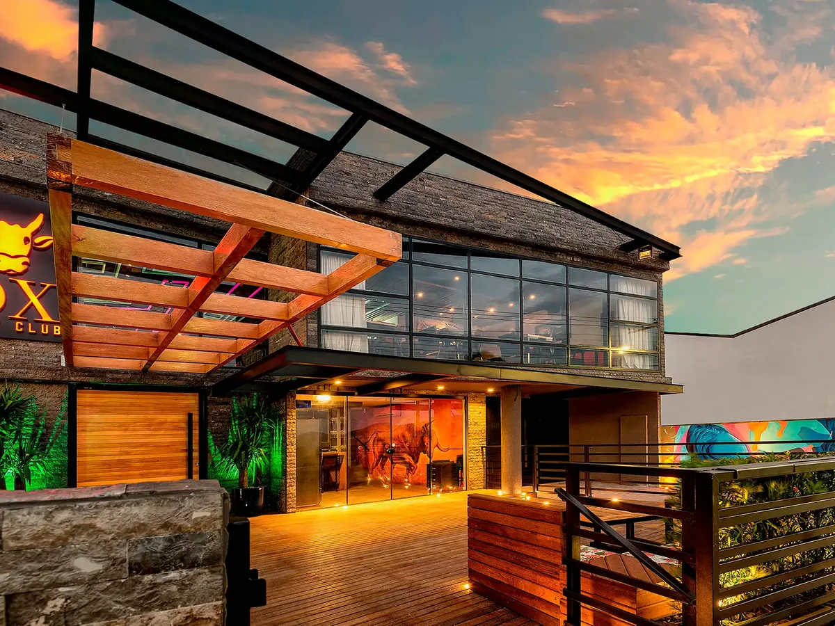 Fachada do OX Beef Club ao anoitecer, retrofit e ampliação pela Progetta Studio