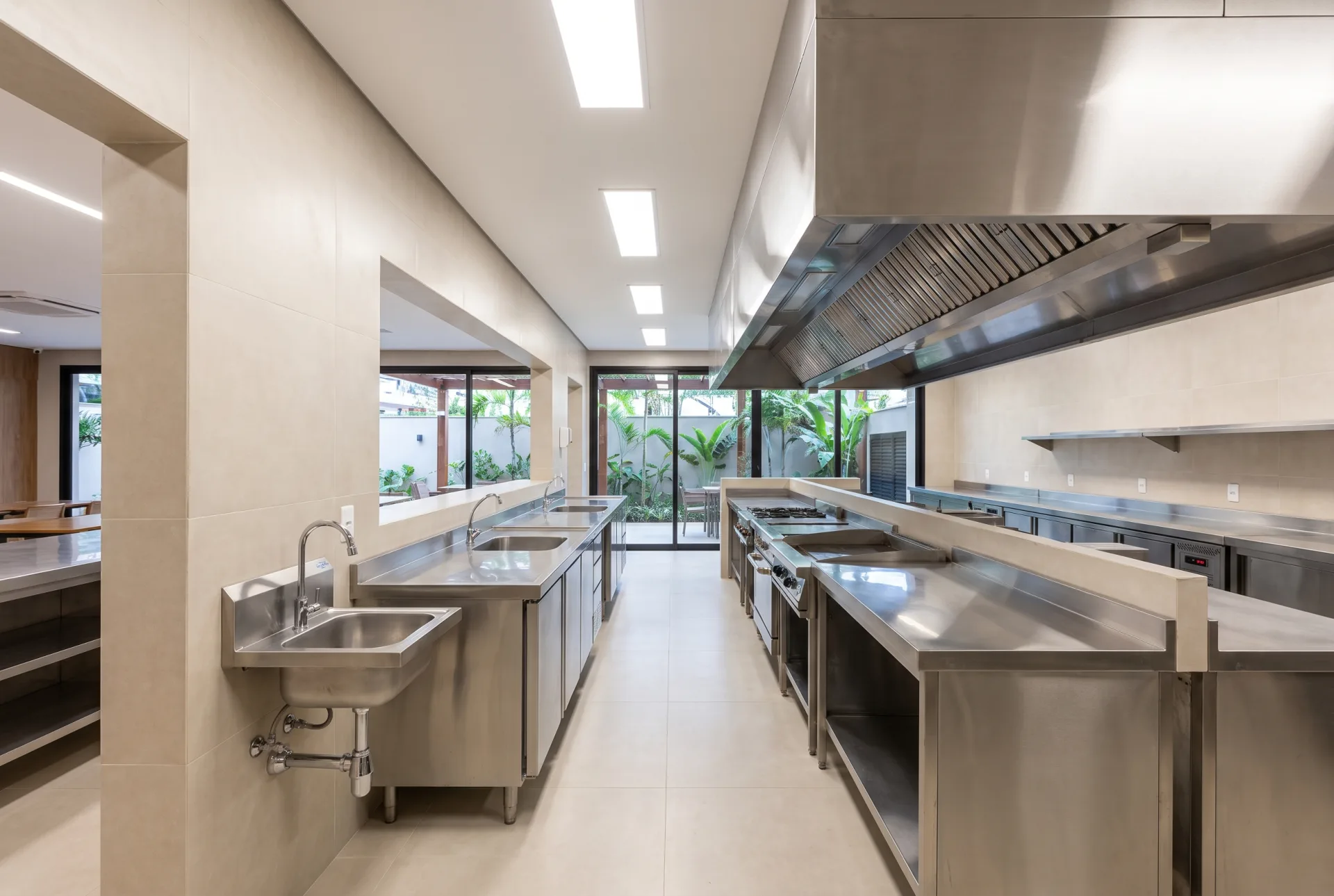 Cozinha profissional de restaurante com bancadas de inox, revestimentos laváveis e lavatório exclusivo para as mãos