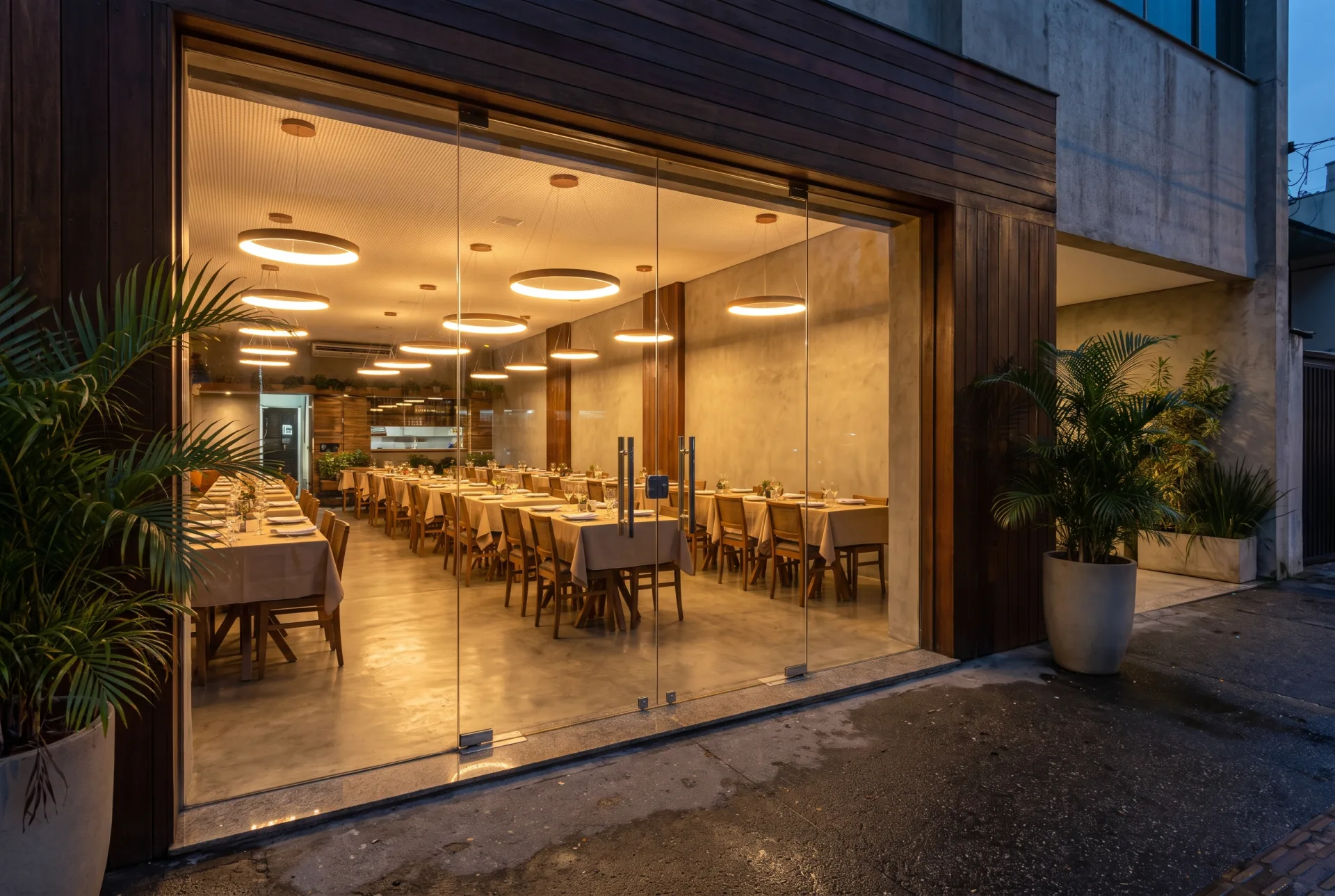 Entrada acessível de restaurante, nivelada com a calçada, e salão com mesas integradas